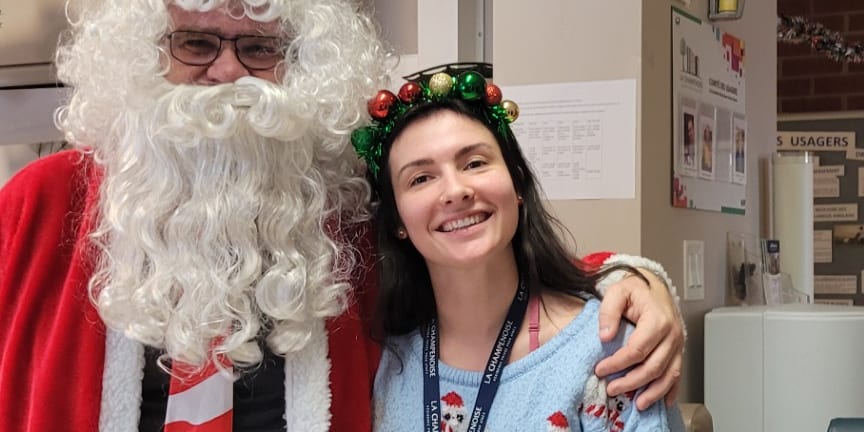 Une employée et le père Noël posant ensemble lors de la fête de Noël